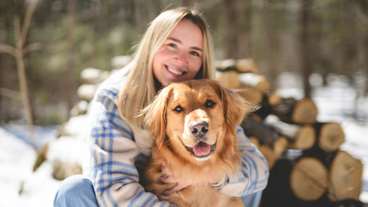  Young woman outside with golden retriever dog.